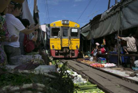 Watch a train run through Thailand's incredible Folding Umbrella Market